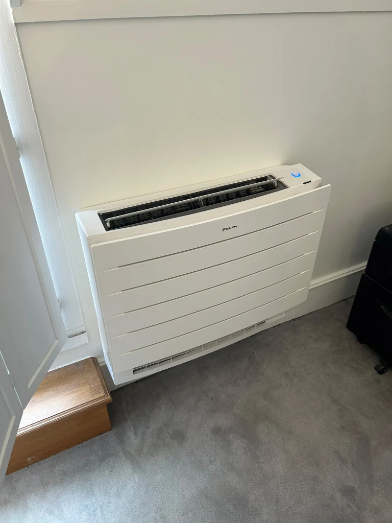 Climatisation réversible Daikin : console au sol intérieure et groupe extérieur sur plots, climaticien Île-de-France