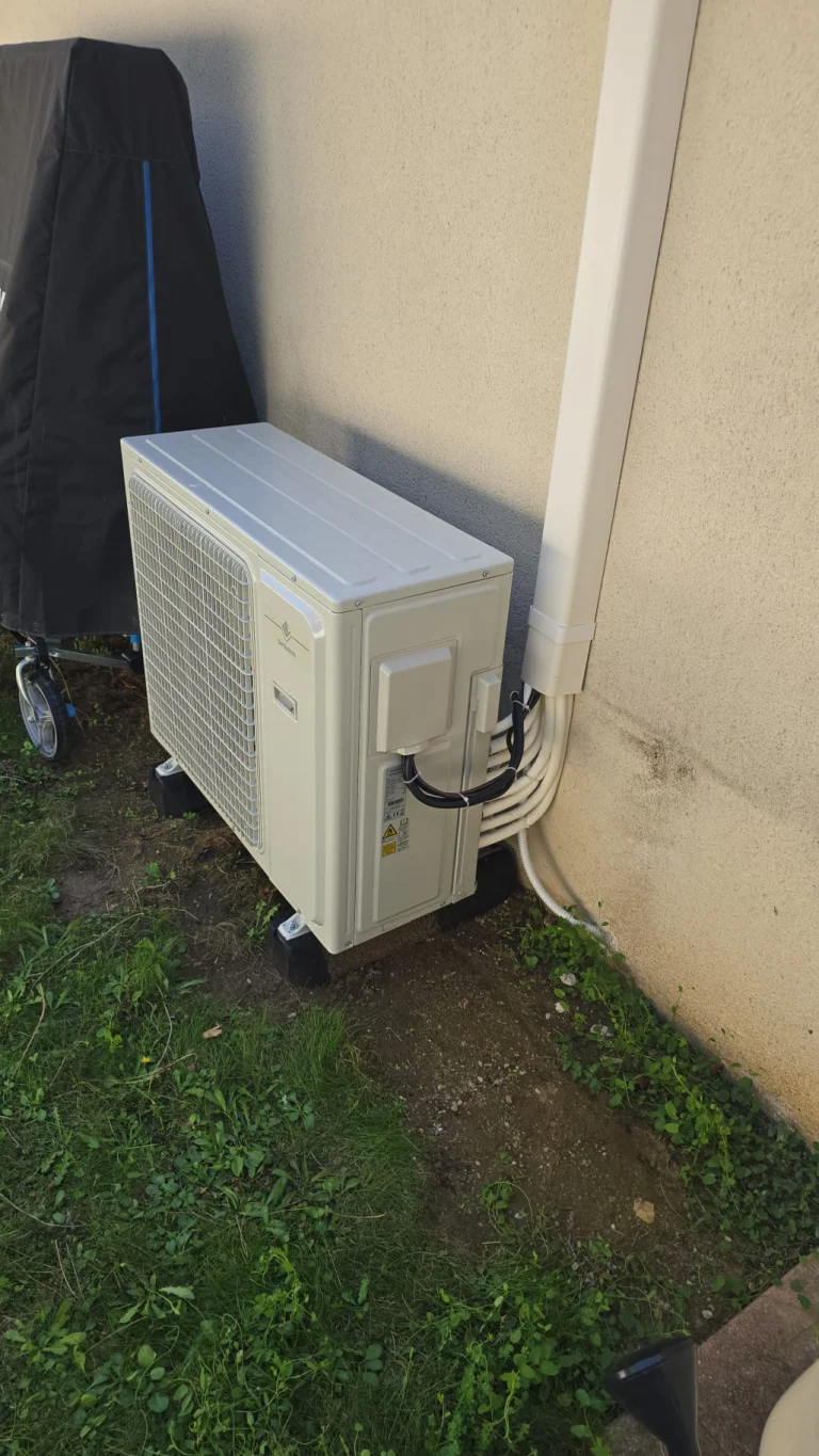 Groupe extérieur de climatisation au sol en pied de façade crépie, climaticien Île-de-France