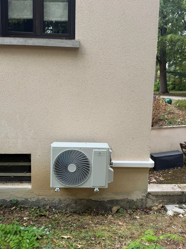 Groupe extérieur de climatisation fixé sur support mural en façade de pavillon, climaticien Île-de-France