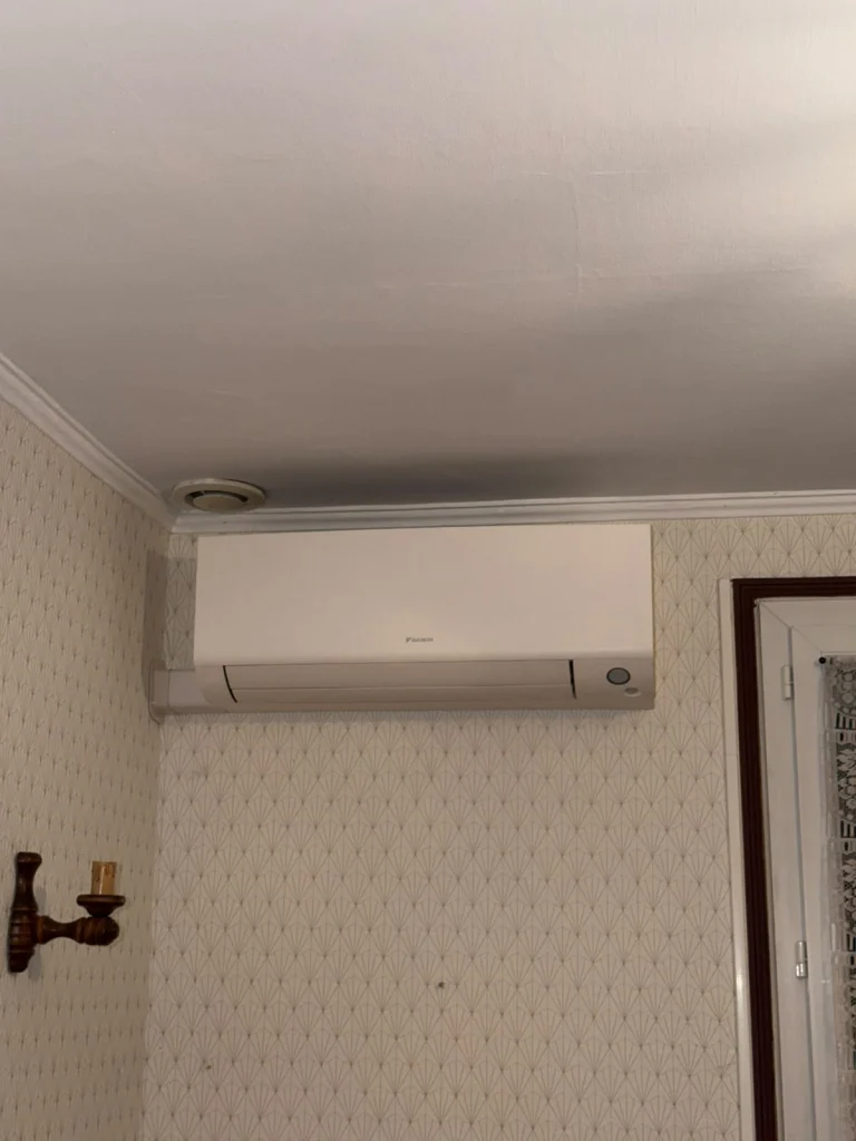 Split mural de climatisation réversible installé dans une chambre, climaticien Île-de-France