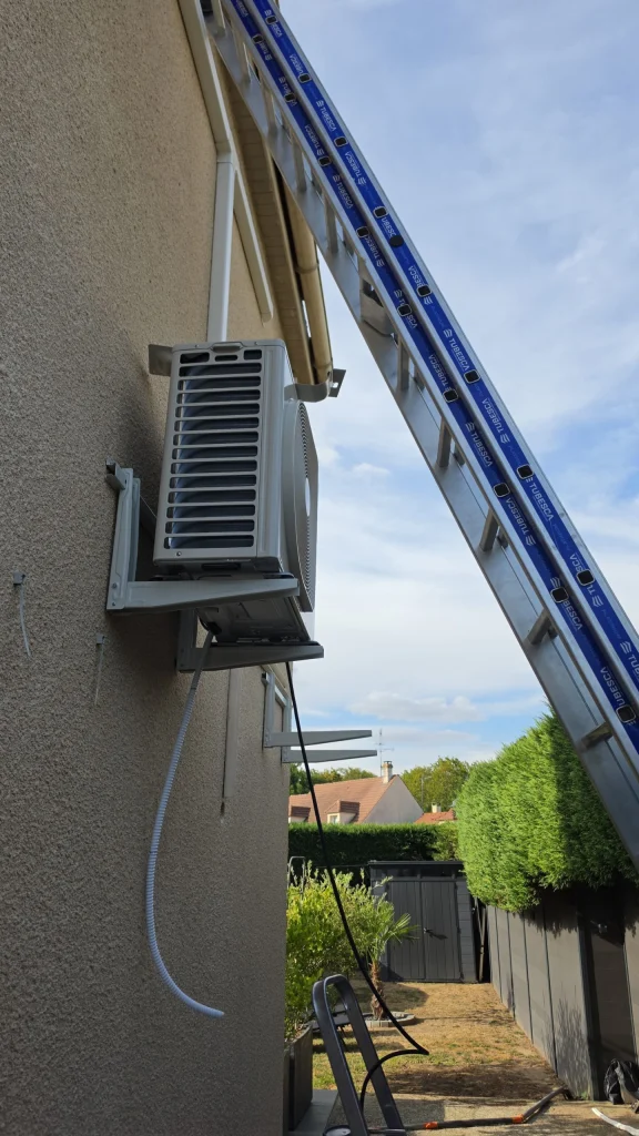 Groupe extérieur de climatisation fixé en hauteur sous un store banne, climaticien Île-de-France