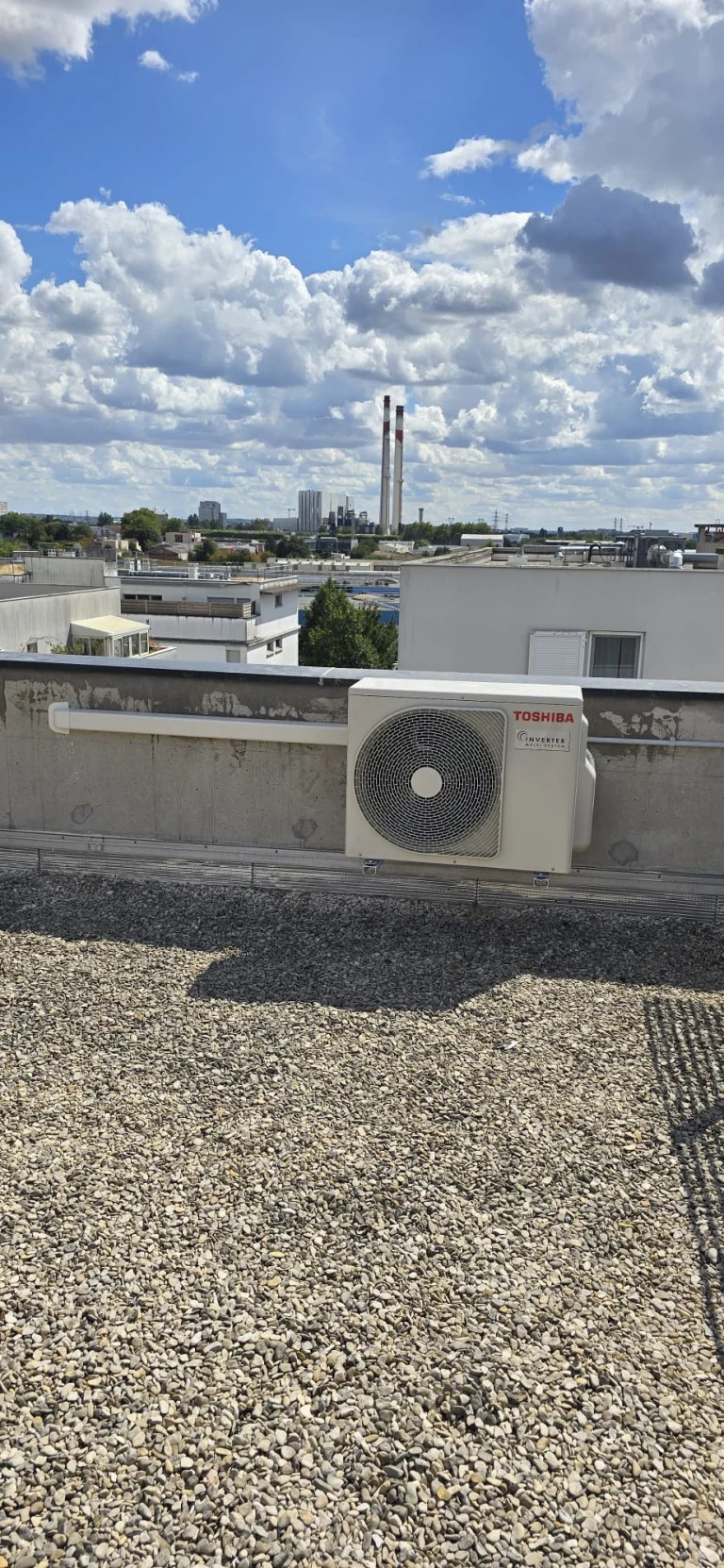 Groupe extérieur de climatisation posé sur une toiture-terrasse gravillonnée d'immeuble, climaticien Île-de-France