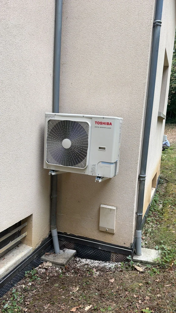 Groupe extérieur de climatisation Toshiba sur support mural, goulotte le long de la gouttière, climaticien Île-de-France
