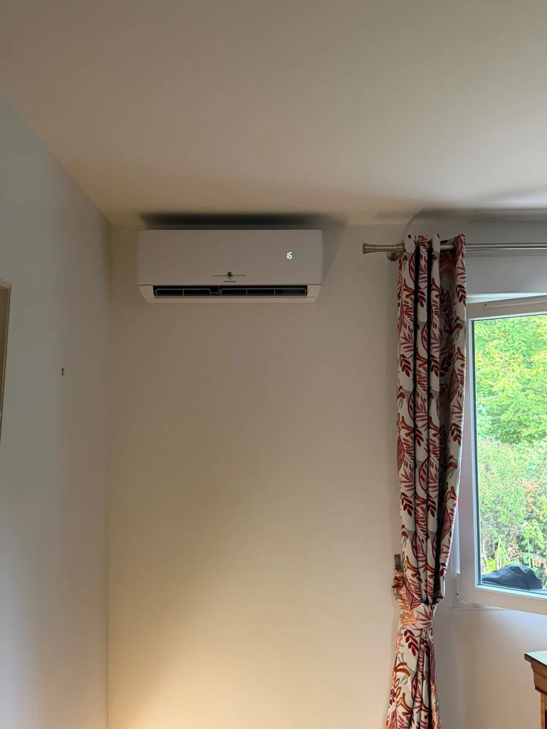 Split mural de climatisation réversible dans un séjour aux murs jaunes, climaticien Île-de-France
