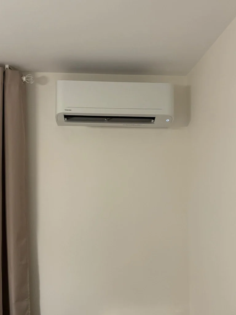 Split mural de climatisation réversible dans un salon, climaticien Île-de-France