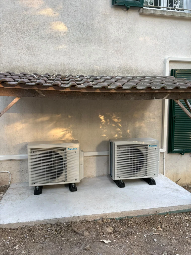 Deux groupes extérieurs de climatisation côte à côte sur une dalle béton, climaticien Île-de-France
