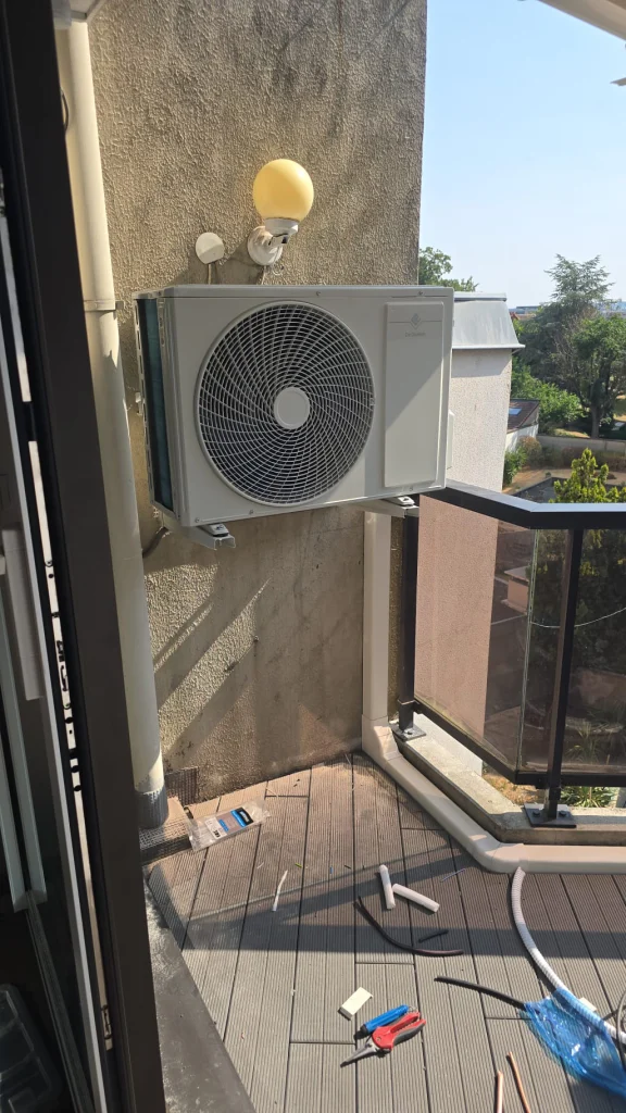Groupe extérieur de climatisation sur support mural au balcon en bois d'un appartement, climaticien Île-de-France