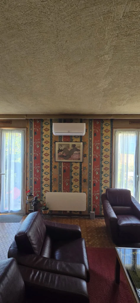 Split mural de climatisation réversible dans un salon au papier peint rayé, climaticien Île-de-France