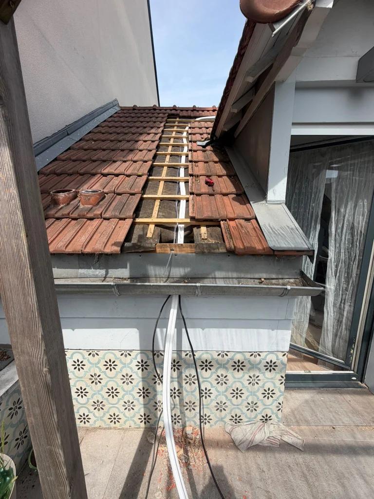 Groupe extérieur de climatisation sur une terrasse en carreaux de ciment, liaisons passées sous les tuiles, climaticien Île-de-France