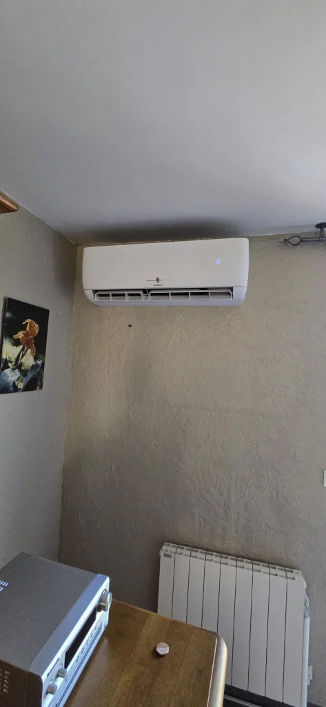 Split mural de climatisation réversible au-dessus d'un radiateur électrique, climaticien Île-de-France