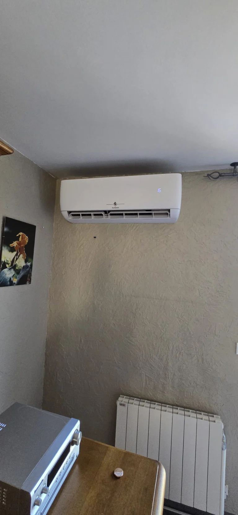 Split mural de climatisation réversible au-dessus d'un radiateur électrique, climaticien Île-de-France