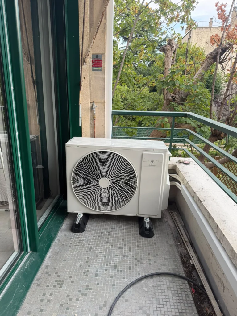 Groupe extérieur de climatisation sur plots au balcon carrelé d'un appartement ancien, climaticien Île-de-France