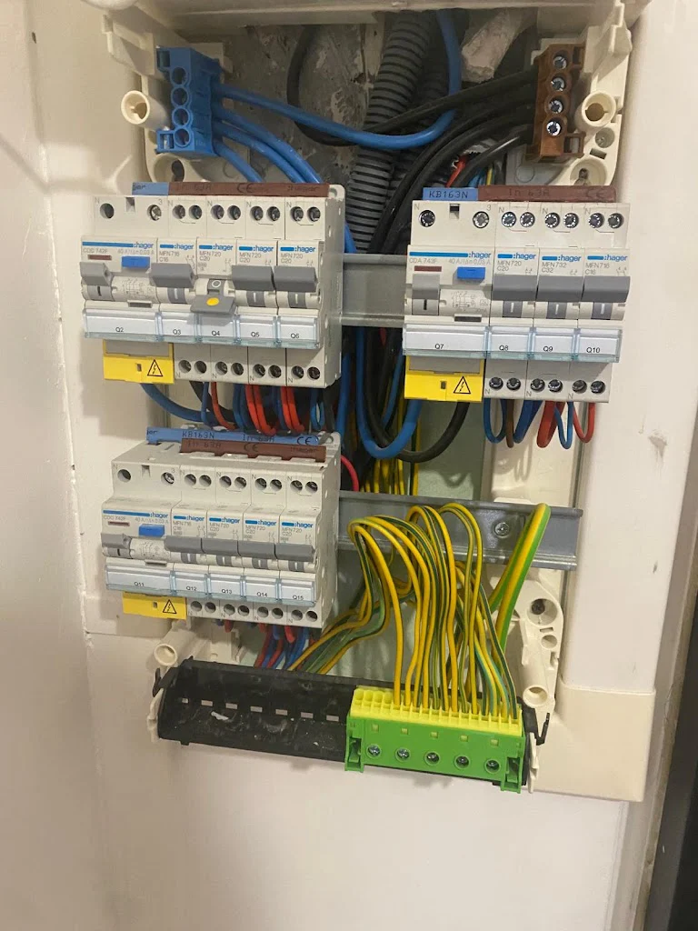 Tableau électrique neuf ouvert en cours de câblage avec peignes, différentiels et bornier de terre, électricien Île-de-France