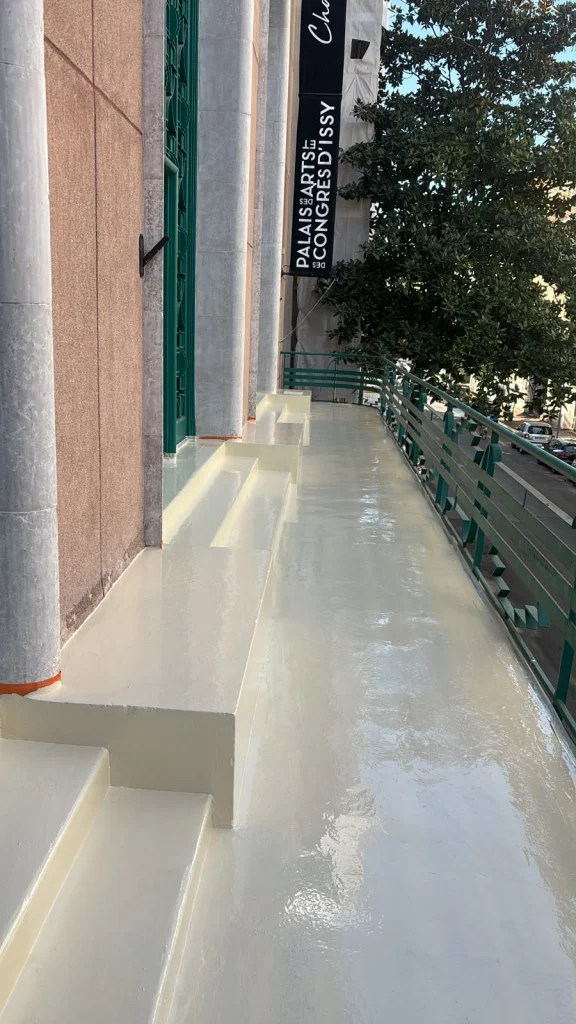 Coursive d'un bâtiment public après application d'une étanchéité liquide armée le long des poteaux, étancheur Île-de-France