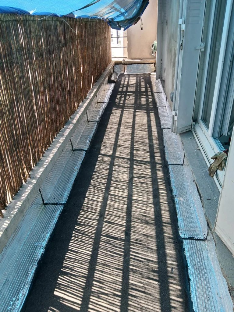 Balcon étroit d'immeuble pendant l'application d'une étanchéité liquide, étancheur Île-de-France