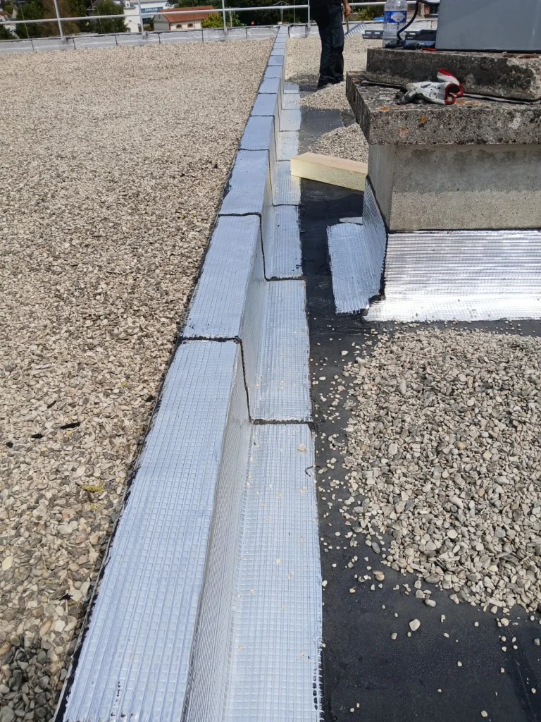 Toiture-terrasse d'immeuble refaite en bitume bicouche sous gravillons avec lanterneaux, étancheur Île-de-France