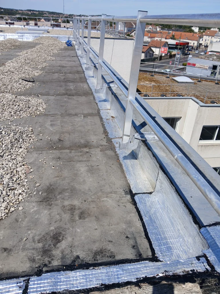 Toiture-terrasse d'immeuble refaite en bitume bicouche sous gravillons avec lanterneaux, étancheur Île-de-France