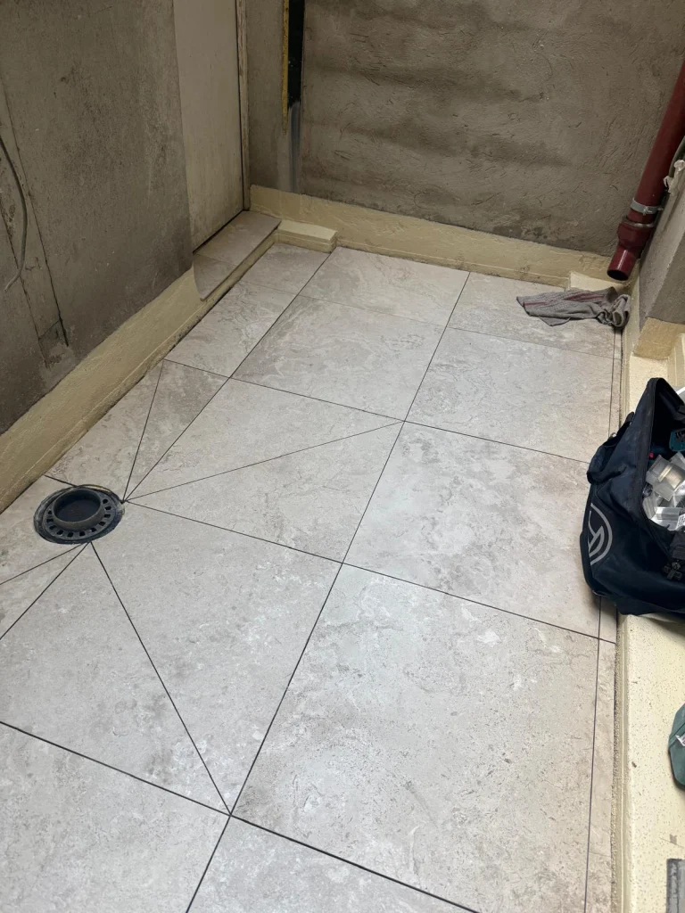 Terrasse d'appartement carrelée en travertin sur une étanchéité neuve avec siphon de sol, étancheur Île-de-France
