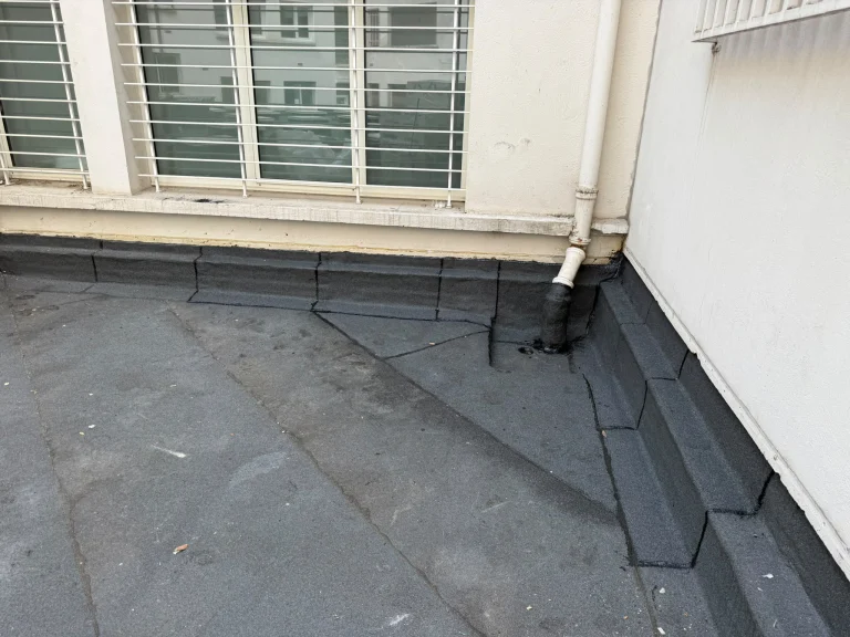 Relevés d'étanchéité bitume au pied d'un brise-soleil et dans les angles d'une terrasse d'immeuble, étancheur Île-de-France
