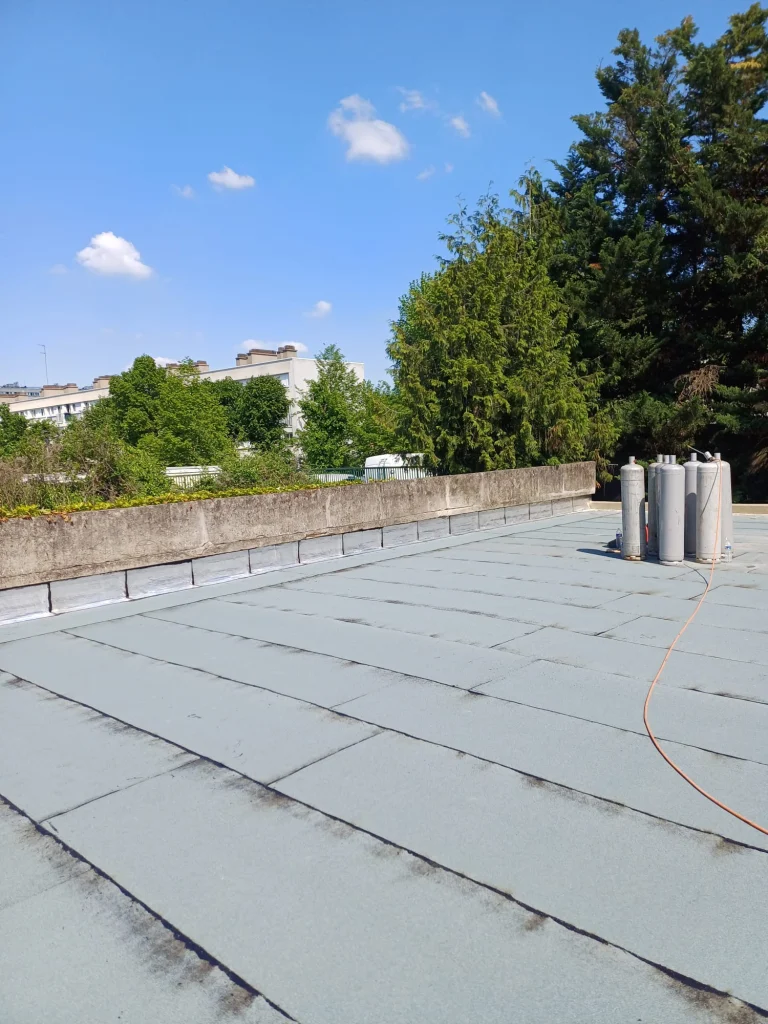 Toiture-terrasse de bâtiment collectif en bitume ardoisé avec sorties de ventilation traitées, étancheur Île-de-France